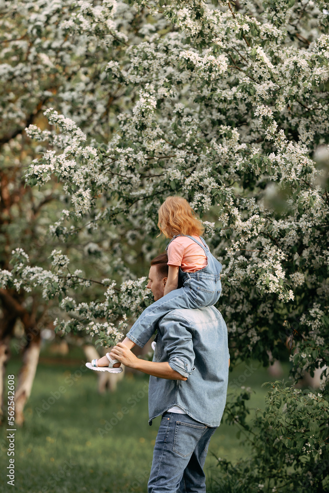 Dad and daughter are hugging under an apple blossom tree. Dad and daughter are hugging under an apple blossom tree.
