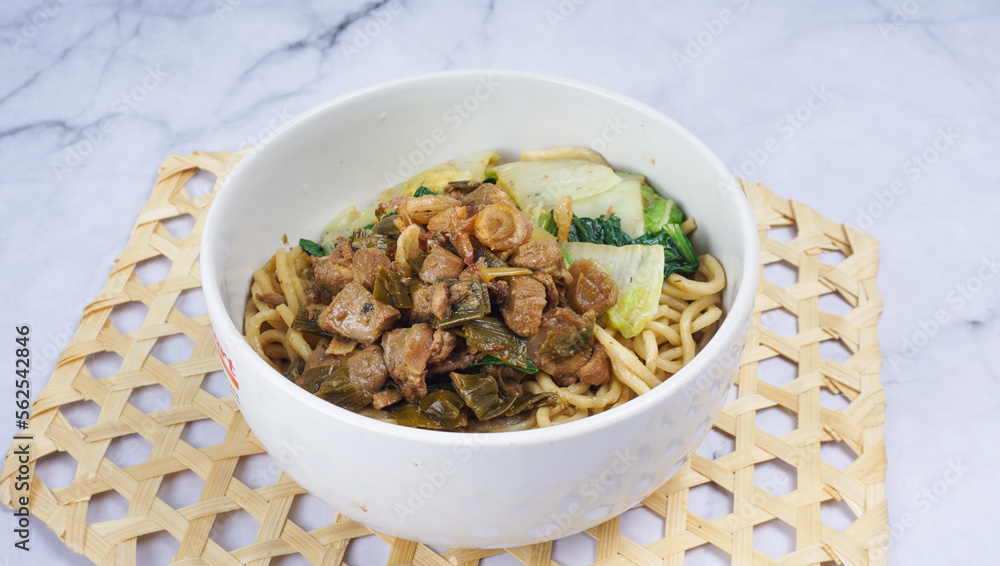 Indonesian food, Mie Ayam or Bami ayam, noodles with chicken and served on white bowl Indonesian food, Mie Ayam or Bami ayam, noodles with chicken and served on white bowl