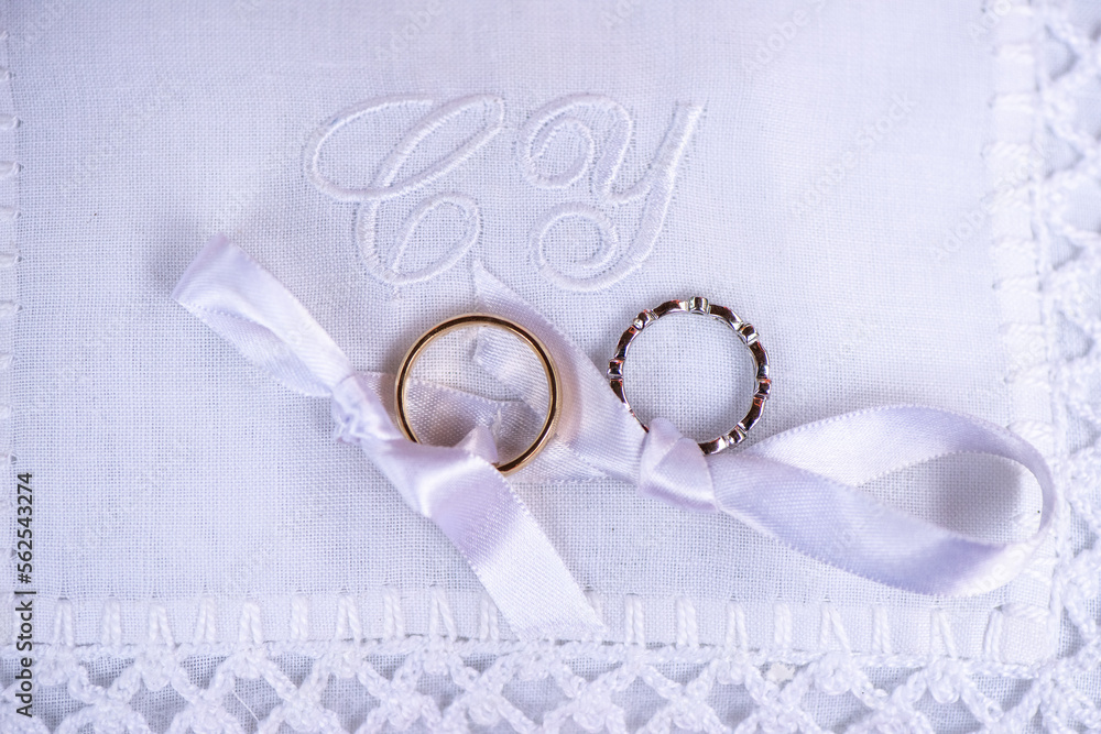 wedding bands on white monogrammed pillow