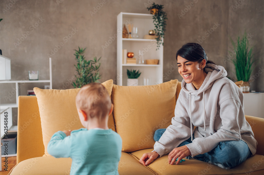 Mom and toddler son playing with dinosaurs toys at home on the couch Mom and toddler son playing with dinosaurs toys at home on the couch