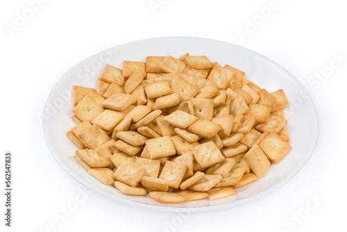 Salty crackers square shape on white dish on white background