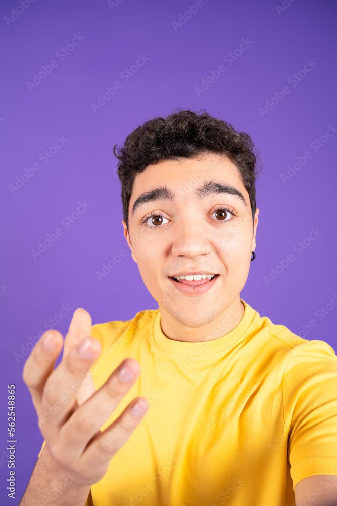 Camera view of teenager boy talking to camera or live streaming isolated on purple background Camera view of teenager boy talking to camera or live streaming isolated on purple background