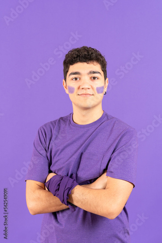 Portrait of proud hispanic feminist teenager boy isolated on purple background. Feminism, equality and woman rights concept.