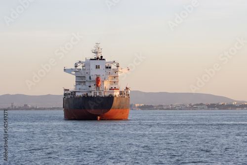 An industrial transport vessel sails on a river