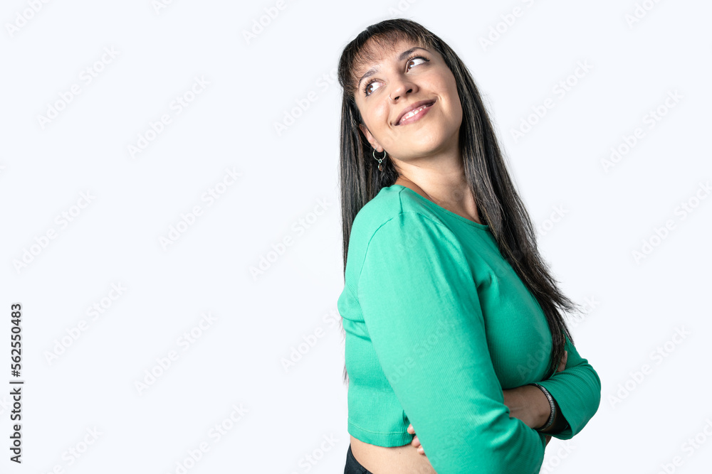 Pretty Latin woman with her arms crossed and looking up in lateral position on white background. Copy space on left side Pretty Latin woman with her arms crossed and looking up in lateral position on white background. Copy space on left side