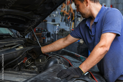 Quadro em tela Car service, repair, maintenance and people concept - auto mechanic looking for a malfunction in the car engine