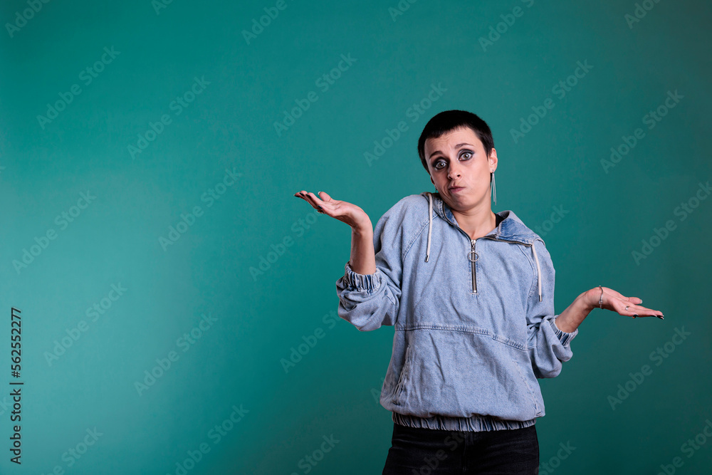 Portrait of confused model with gorgeous makeup posing on isolated background in studio making uncertain facial expression. Young woman shrugging shoulders while doing i dont know gesture Portrait of confused model with gorgeous makeup posing on isolated background in studio making uncertain facial expression. Young woman shrugging shoulders while doing i dont know gesture