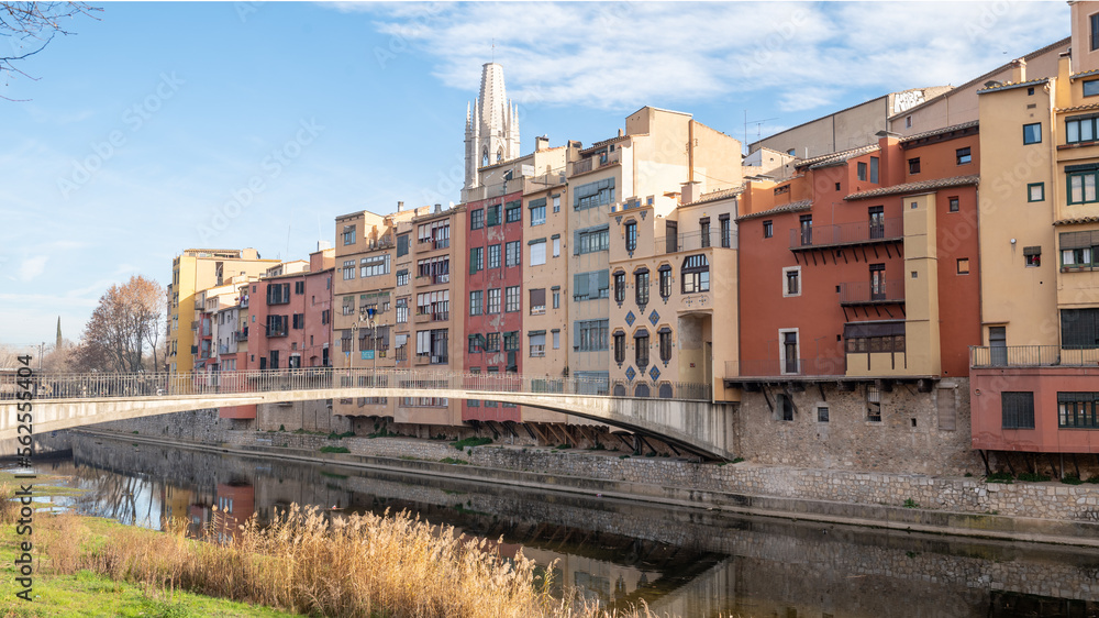 Colorful houses reflected in the Onyar river, in Girona, Catalonia, Spain. Church of Sant Feliu and Cathedral of Santa María in the background