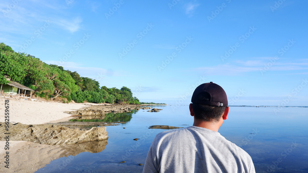 Back of man wearing a hat who is looking at the blue beaches, islands and beautiful blue sky
Back of man wearing a hat who is looking at the blue beaches, islands and beautiful blue sky