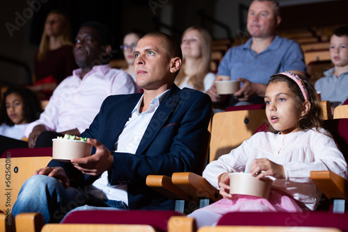 parents with children sitting at movie in cinema