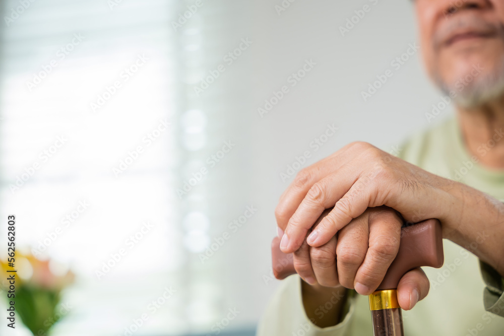 Close up hands of Asian Elderly hand holding handle of cane, senior disabled man holding walking stick, Old man sitting resting at home hold wooden walking cane, International Day for the Elderly Close up hands of Asian Elderly hand holding handle of cane, senior disabled man holding walking stick, Old man sitting resting at home hold wooden walking cane, International Day for the Elderly