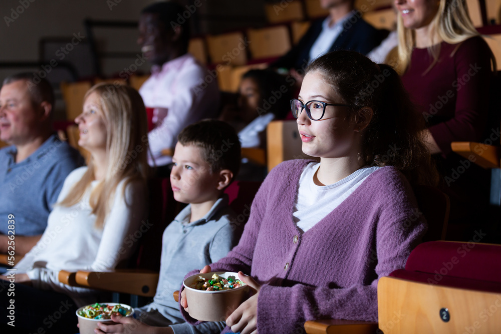 caucasian children sitting at film in auditorium