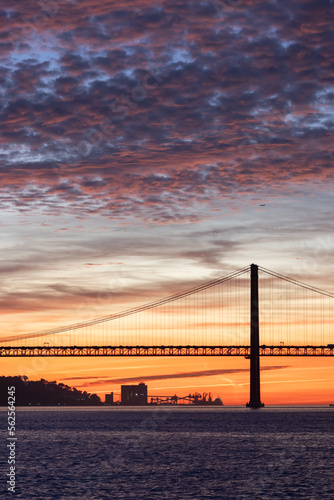 Lisbon 25th of April Bridge at sunset and industrial cranes at the background © KONSTANTIN SHISHKIN