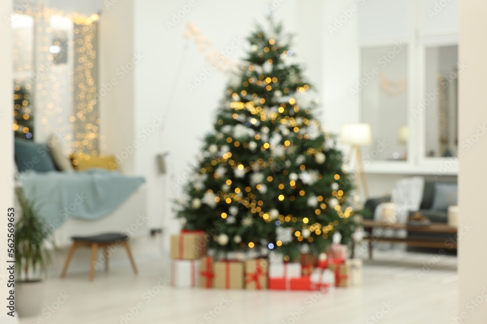 Blurred view of decorated Christmas tree and gift boxes in living room. Interior design