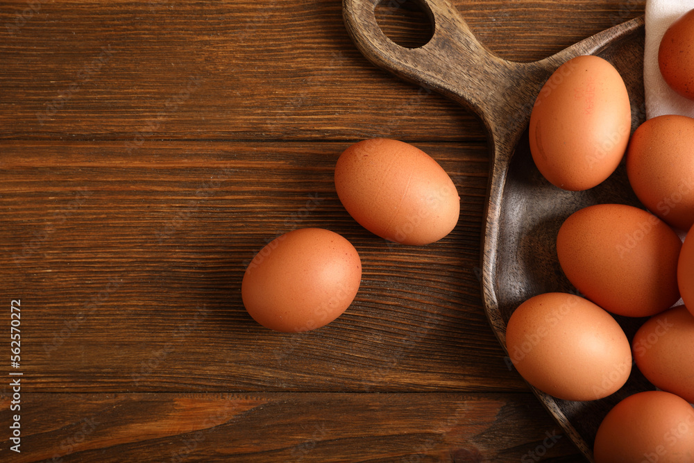 Raw brown chicken eggs on wooden table, flat lay. Space for text Raw brown chicken eggs on wooden table, flat lay. Space for text