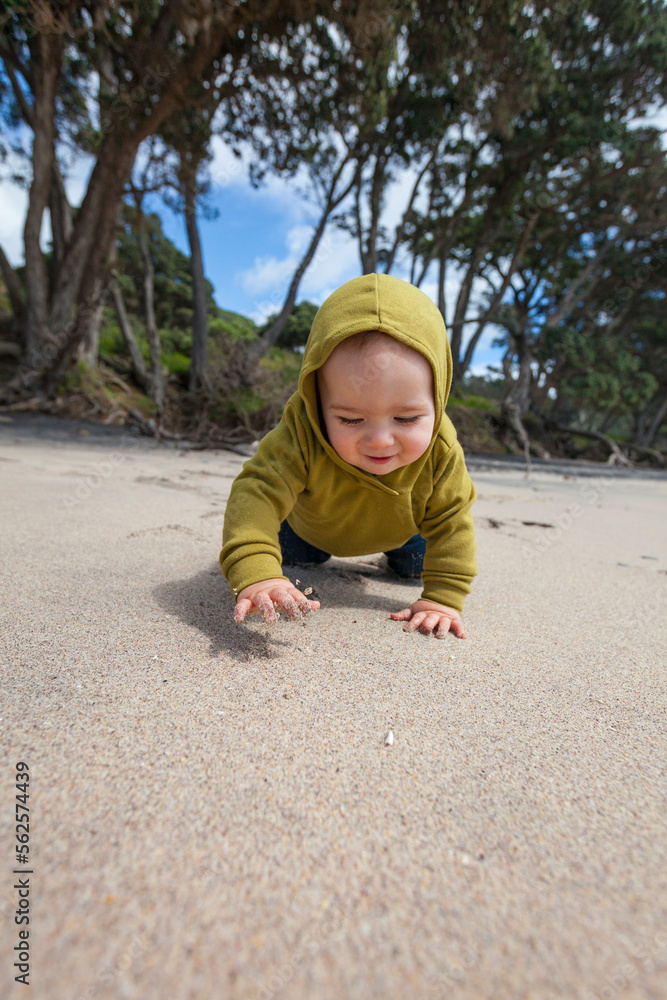 Young boy crawling at Waihi Beach in Orokawa Scenic Reserve, New Zealand Young boy crawling at Waihi Beach in Orokawa Scenic Reserve, New Zealand