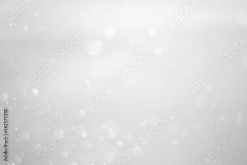 White glitter vintage lights background.  White bokeh shiny on dark background.