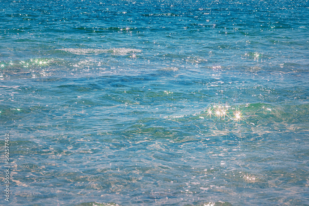 Blue sea with reflections on the water and light waves as a background. Sea background.