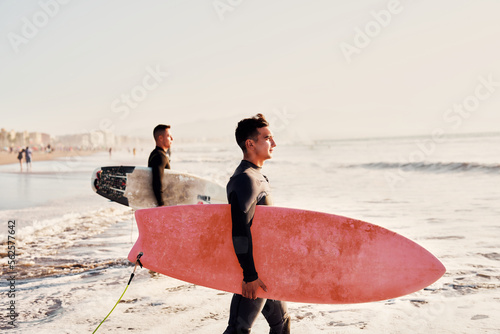 young latino surfers entering the water to surf in La Serena