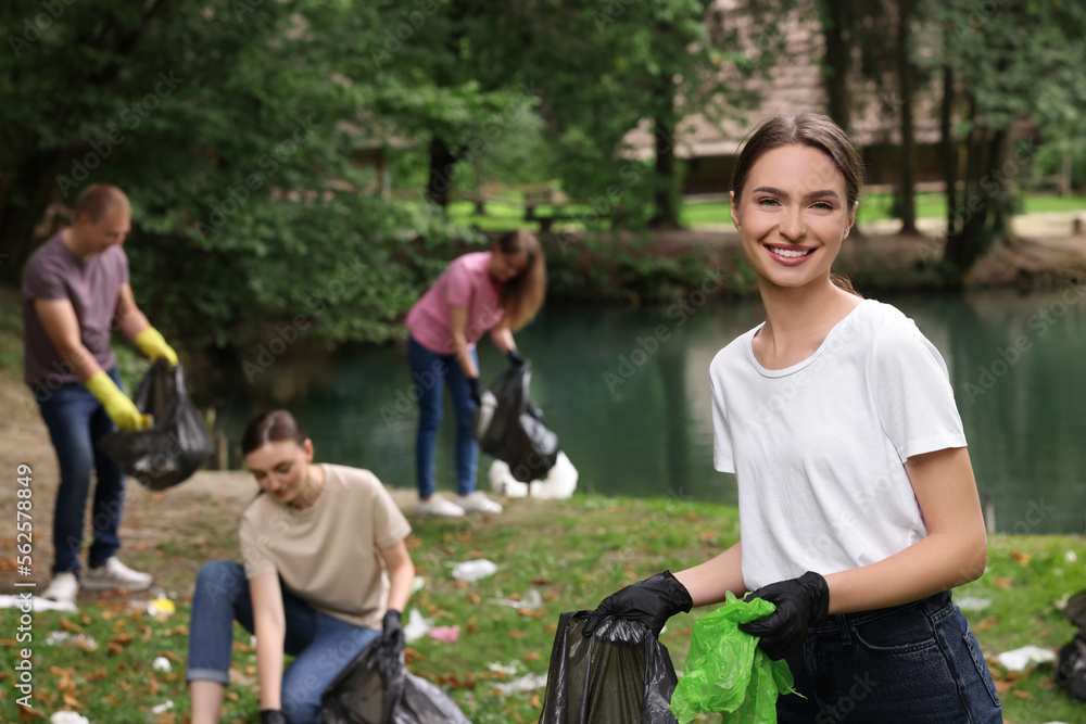 Group of people with plastic bags collecting garbage in park Group of people with plastic bags collecting garbage in park