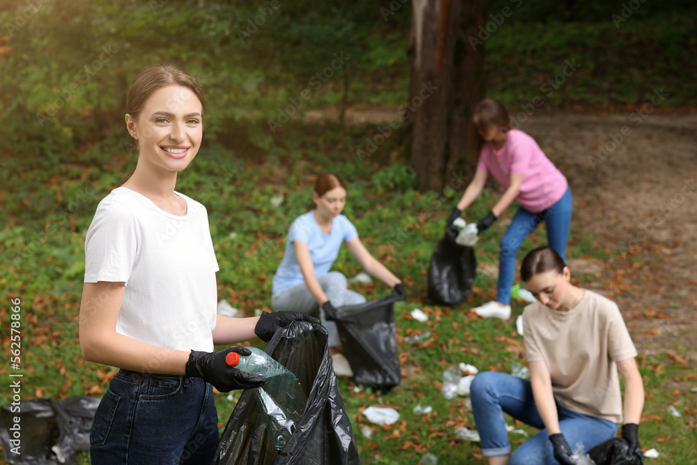 Group of people with plastic bags collecting garbage in park Group of people with plastic bags collecting garbage in park