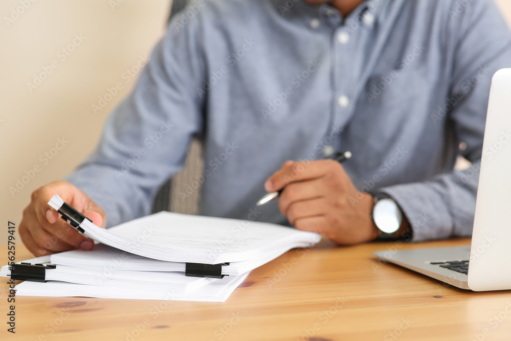 Man working with documents at wooden table in office, closeup Man working with documents at wooden table in office, closeup