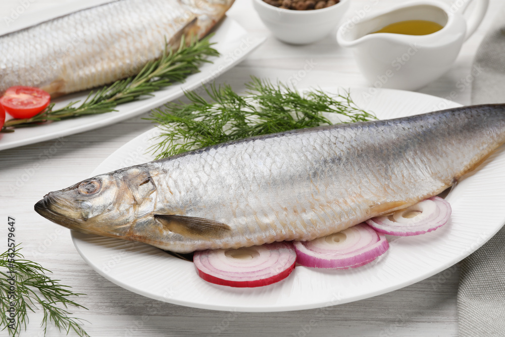 Delicious salted herrings and ingredients on white wooden table Delicious salted herrings and ingredients on white wooden table