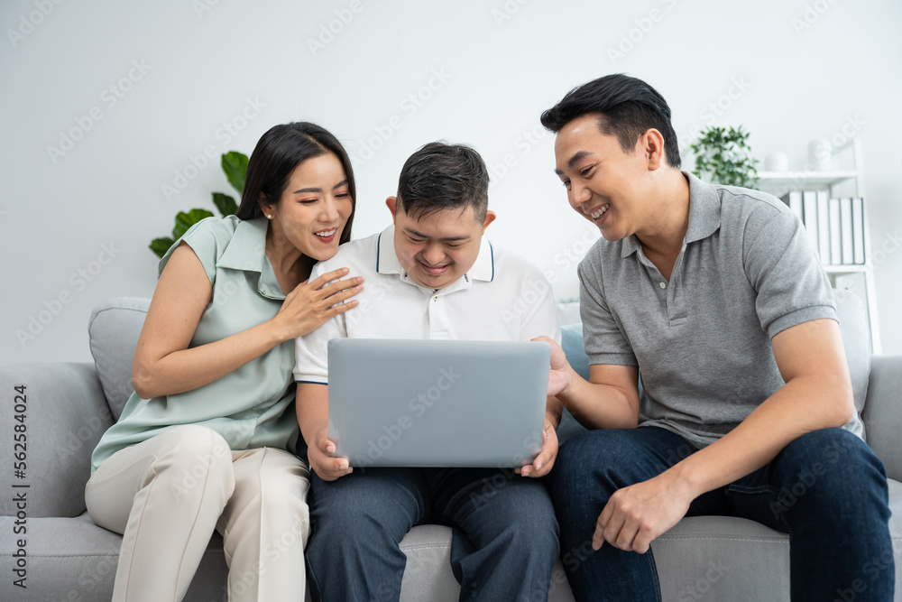 Asian happy family, parents using laptop with young son in living room. Asian happy family, parents using laptop with young son in living room.