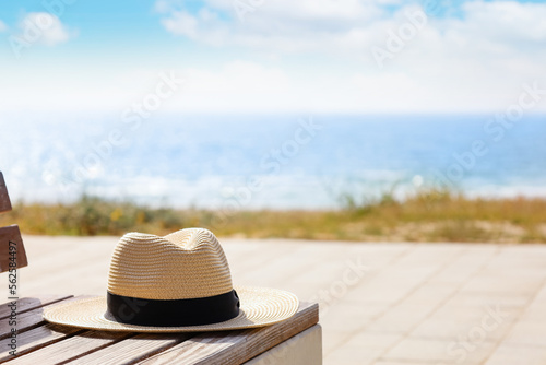 Photography Summer hat on bench at sea resort, closeup