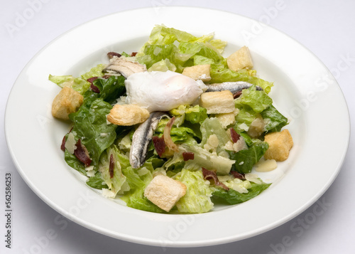 Caesar Salad romaine cos lettuce with poached egg, croutons, anchovies and bacon.