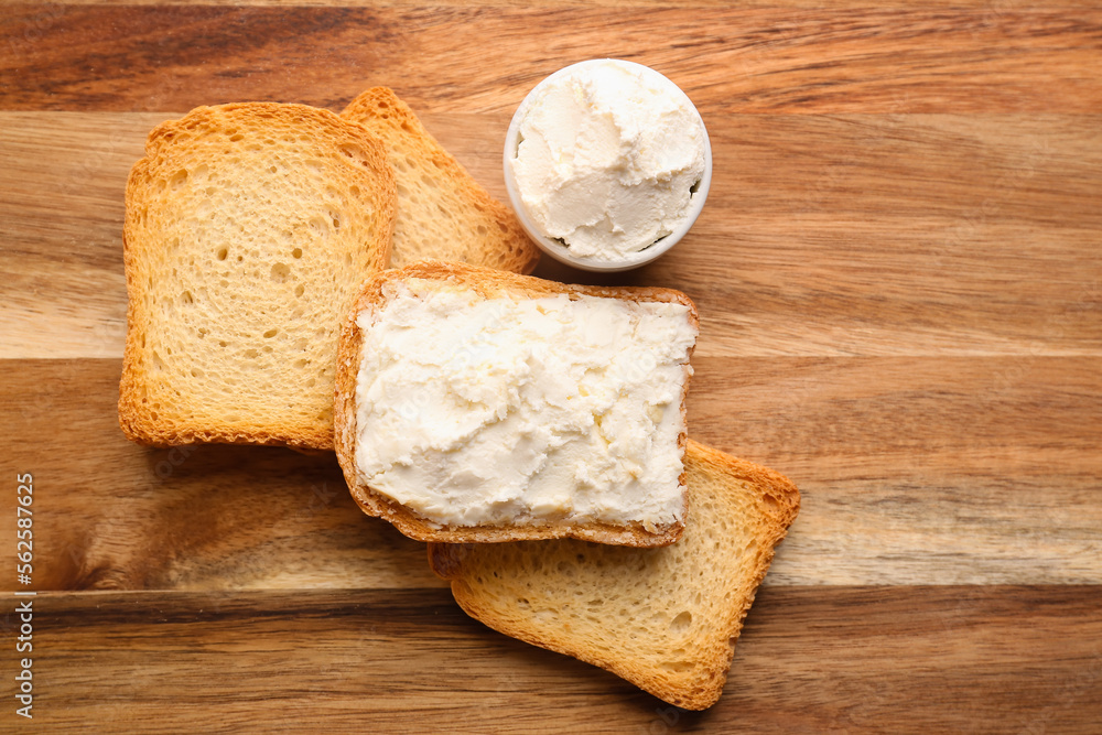 Toasts with tasty cream cheese on wooden background Toasts with tasty cream cheese on wooden background