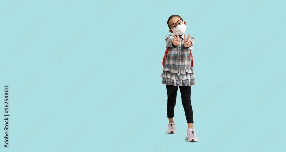 School girl, Happy Asian student wearing medical face mask with hand is show two Finger symbols of peace strength fight, victory symbol, Full body portrait isolate on blue background clipping path School girl, Happy Asian student wearing medical face mask with hand is show two Finger symbols of peace strength fight, victory symbol, Full body portrait isolate on blue background clipping path
