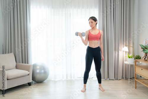Asian woman exercise and stretching in her bed room, her try to make slim by take Yog