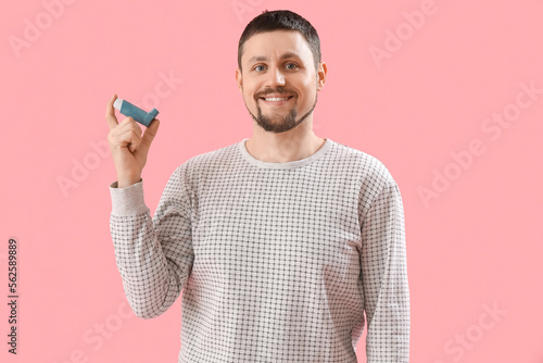 Man with inhaler on pink background