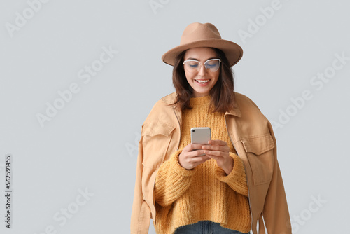 Young woman in hat using mo...