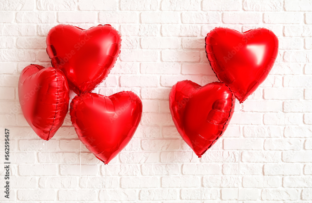 Heart shaped balloons for Valentine's Day on white brick background Heart shaped balloons for Valentine's Day on white brick background