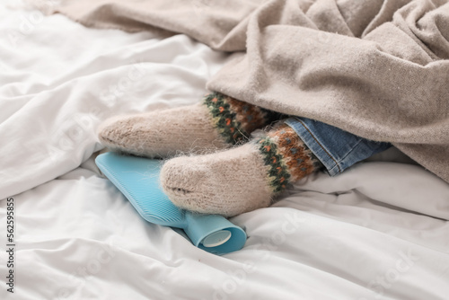 Feet of ill boy with hot water bottle in bedroom, closeup