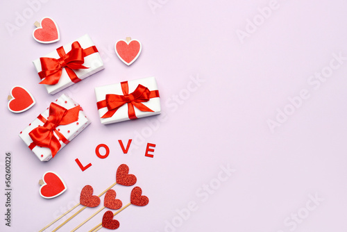 Gift boxes, word LOVE and hearts on lilac background. Valentine's Day celebration © Pixel-Shot