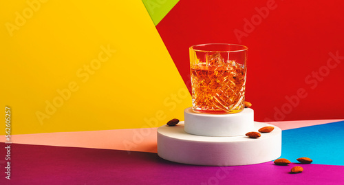 French connection alcoholic cocktail with cognac and amaretto liqueur. Modern style still life on fashionable multicolored background photo