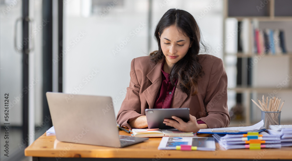 Freelancer Happy business Asian woman in knitwear taking notes at laptop sitting at desk office, finance concept.
Freelancer Happy business Asian woman in knitwear taking notes at laptop sitting at desk office, finance concept.