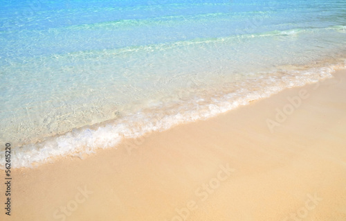 Sand beach sea on sun light with sea wave.