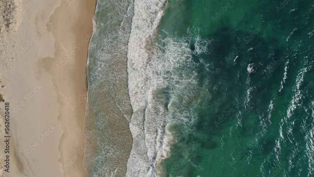 Top down drone shot of waves rolling onto the beach in Tarifa, Spain. Top down drone shot of waves rolling onto the beach in Tarifa, Spain.