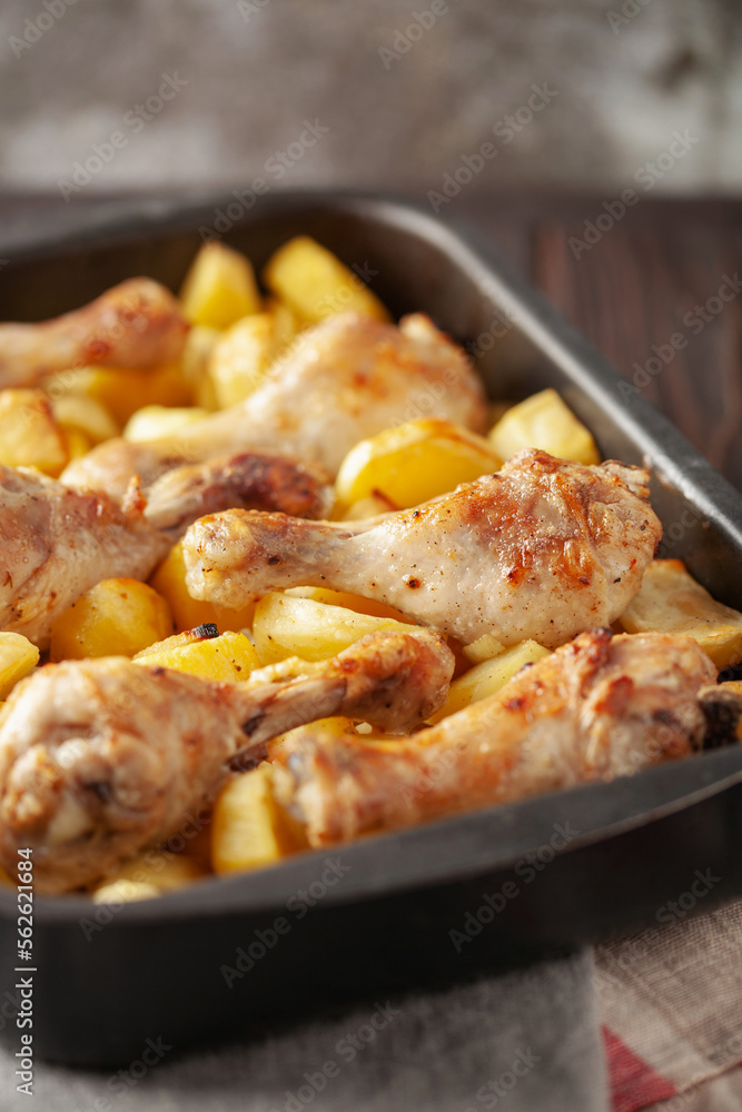 Roasted chicken legs with potatoes in  roasting pan. Comfort home food