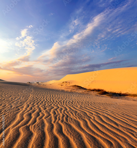 Sand dunes near Mui Ne. Group of off roads on top of dunes in background. Sunny day with blue sky