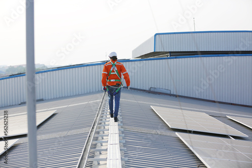 A worker is fixing solar panels on the roof. Engineer and technician using laptop checking and operating solar panels system on rooftop of solar cell farm power plant  Renewable energy source.