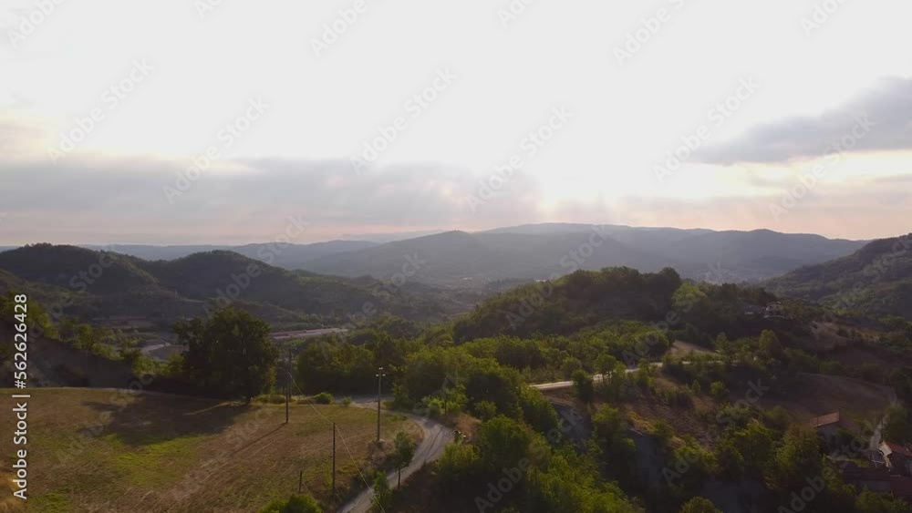 Aerial wide shot of a beautiful Italian mountain valley on a sunny day. Beautiful overview of a wide forest with a road at sunset in Tuscany. Drone shot of typical mountain range, 4k. Aerial wide shot of a beautiful Italian mountain valley on a sunny day. Beautiful overview of a wide forest with a road at sunset in Tuscany. Drone shot of typical mountain range, 4k.
