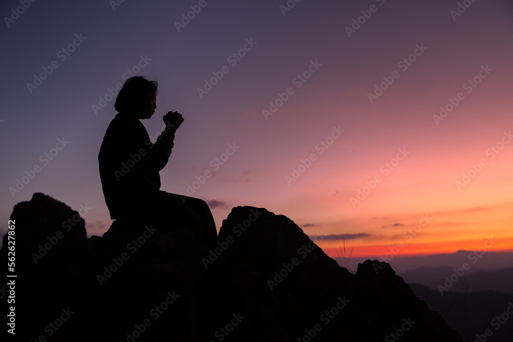Faith christianity of christian worship concept. Spiritual prayer hands over sun shine with blurred beautiful sunset background. Woman praying to god with hopeful blessing against sunset.