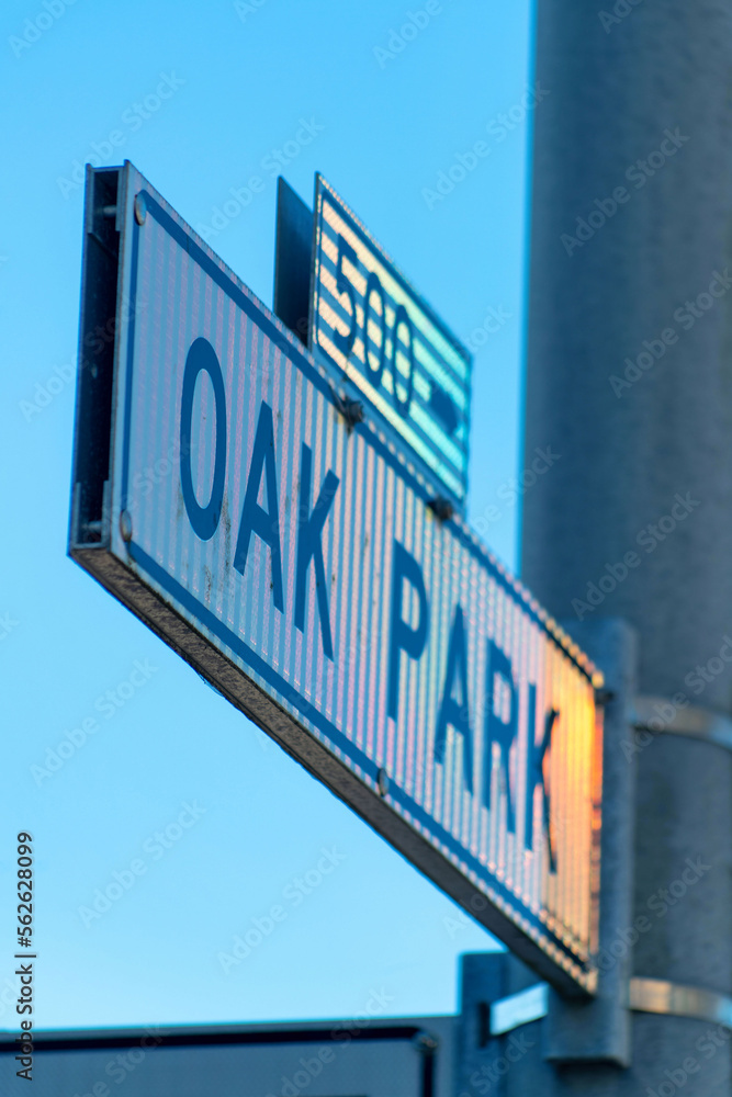 Black and white sign that says oak park in the historic districts of downtown san francisco california on cement light pole