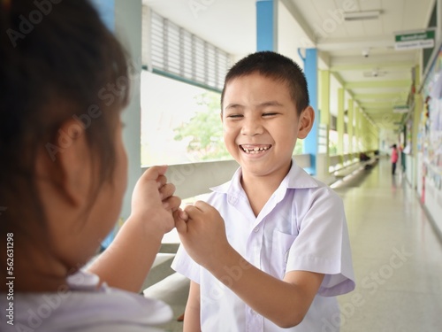 Foto A pair of girls and boys are using little fingers to band together as a promise at the school