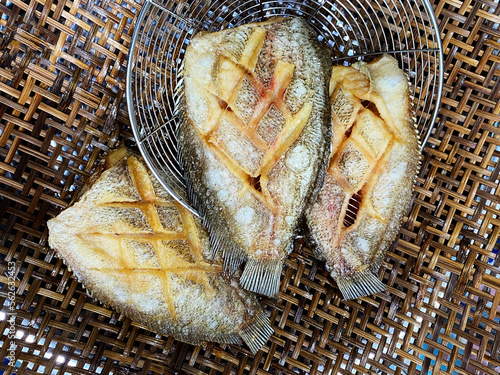 Deep fried Snakeskin gourami fish with spawns on white arches oil paper sheet photo